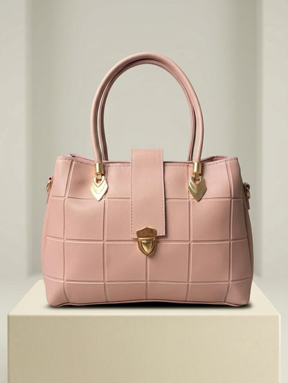 Rose pink quilted satchel with gold turn-lock closure and heart charms front view